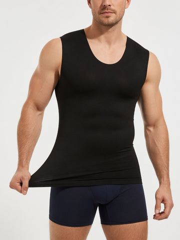 A muscular man wearing a black sleeveless tank top and navy blue boxer briefs, holding the hem of the tank top to show its stretch, against a plain light gray background.