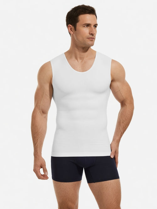 A muscular male model wearing a white sleeveless tank top and dark navy boxer briefs, standing against a plain light gray studio background.